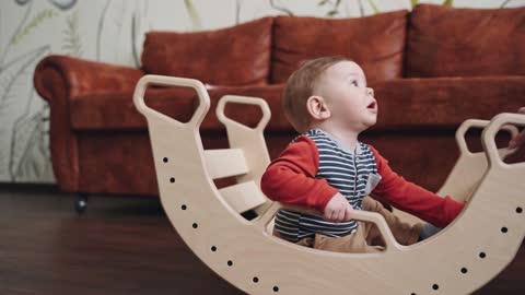 A little baby sitting on a wooden chair