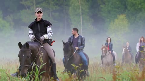 Group of young athletic people walk on beautiful horses early in the morning