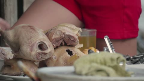 Close-up shot of table with ducks, drinks and tableware in the street