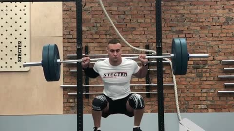 Man Is Doing Barbell Squats On A Seesaw