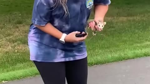 A young woman found a baby opossum in the middle of the road.