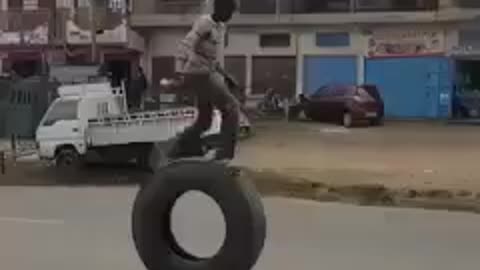 boy playing with big truck tire