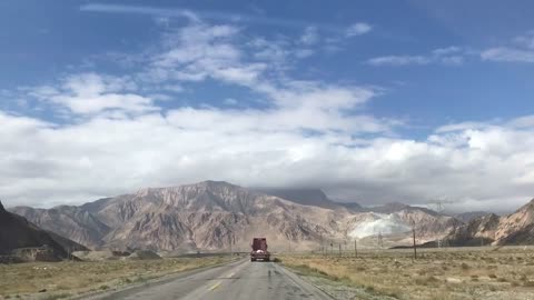 Driving in the beautiful scenery of green mountains and white clouds