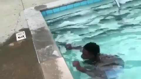 A man squatting in a swimming pool suddenly jumped up