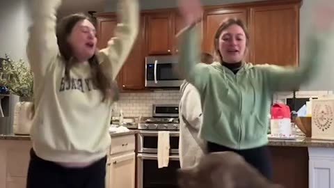 Dog jumps along with Girls as they sing for him