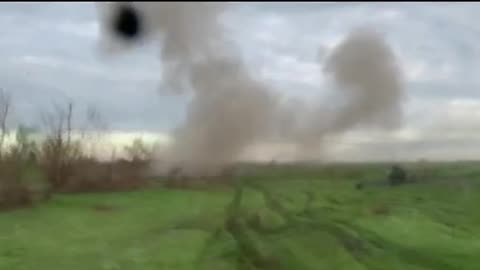 Ukrainian military driving through a shelled field.