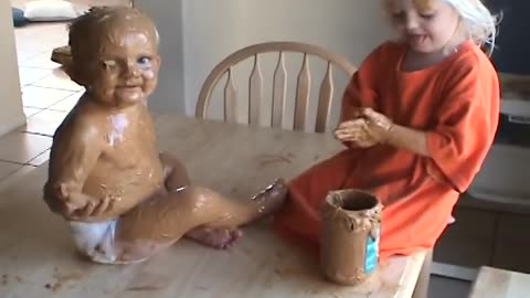 Sister Covers Baby Brother in Peanut Butter