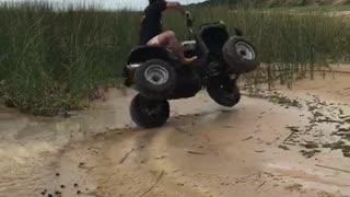 Man on black four wheeler flips