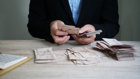 Man counting bank note Thai Baht money.