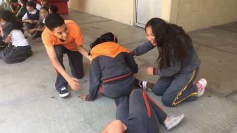 School girls spinning on shoulder one falls off