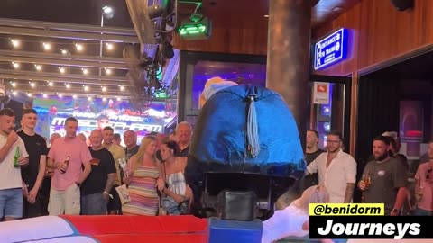 Blonde Girl in Denim Dress Riding on a Bull in Benidorm 4K