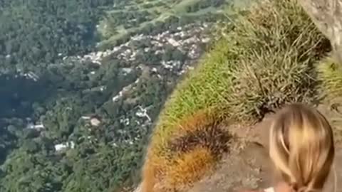 She is brave enough to stand on the edge of the cliff and look at the city in the distance.