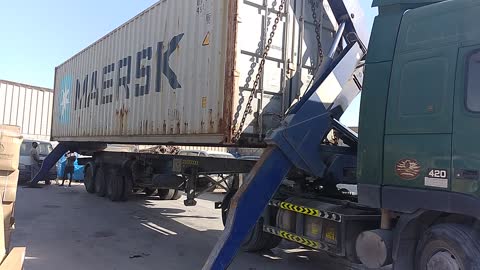 Truck crane showcasing with container by grounding.