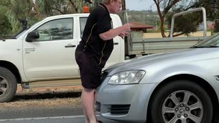 Perturbed Person Climbs onto Moving Car