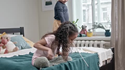 Kids Playing Catch The Bait With Their Cat In The Bedroom