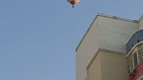 hot air balloon over houses