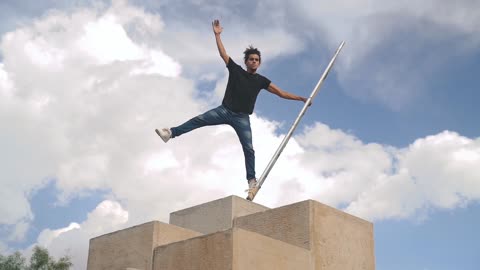 MAN BALANCING ON POLE