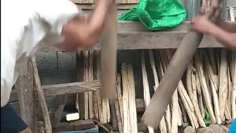 Pounding rice using mortar and pestle in the Philippines