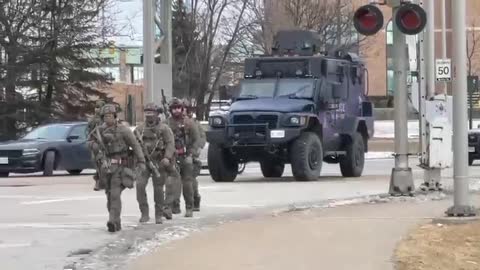 Police, some in military-style gear, move in to remove the protesters blocking the US-Canada