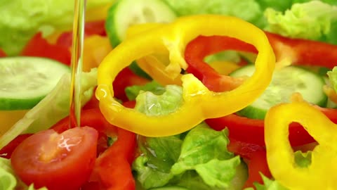 Slices of vegetables falling over salad