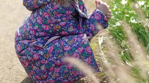 cute baby holding flower plant in mouth