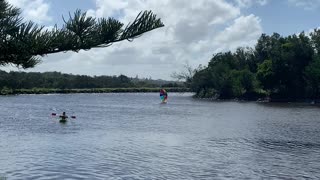 Giant Umbrella Helps Surfboarder Glide Down River