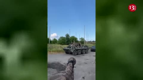 An image of Ukrainian fighters leaving for the front line with armored personnel carrier and tanks