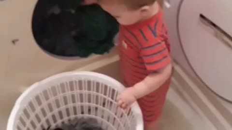 Helpful Little Boy Assists Mommy With The Laundry