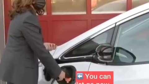 Kamala trying to recharge an electric car thinking she has to stand there and hold it