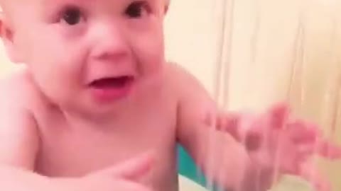 Little funny baby playing with water