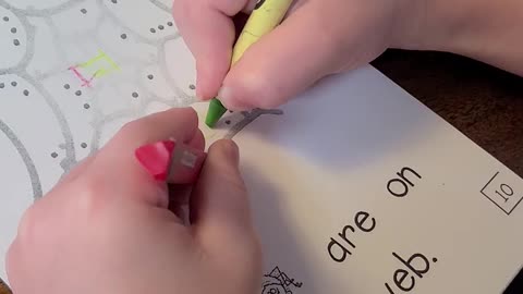 Kindergartner coloring with two hands