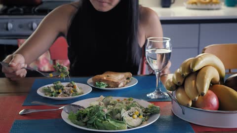 Girl eating salad in her kitchen dining room