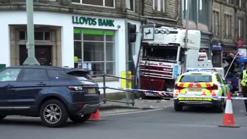 Recovery Truck Towing Bus After Crashing Into Shop's