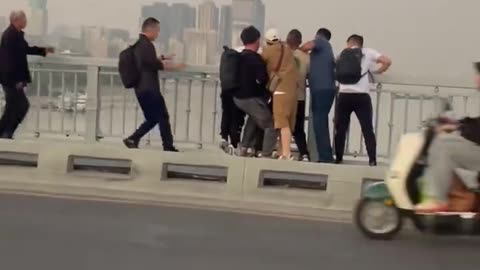 The crowd saved a woman who was about to jump off a bridge to commit suicide.