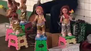 Man playing flute dancing dolls around him