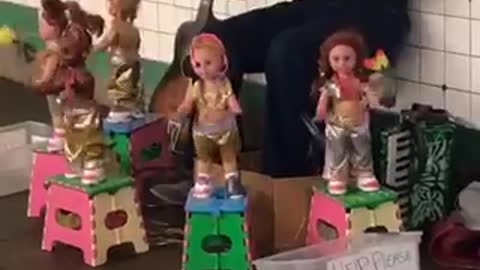 Man playing flute dancing dolls around him