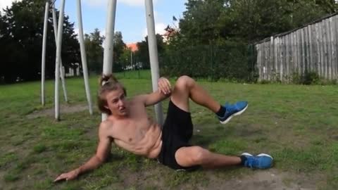 Shirtless guy tries to do flip monkey bars hits leg on bar falls