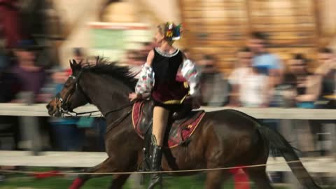 Kopachiv, Ukraine. Cossack girl rides a horse and performs tricks