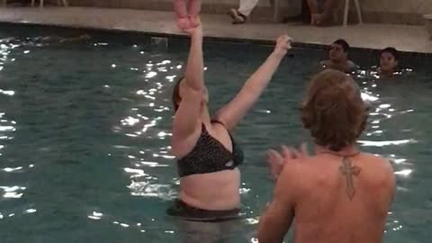 Baby Balances on Mom's Hand in Pool