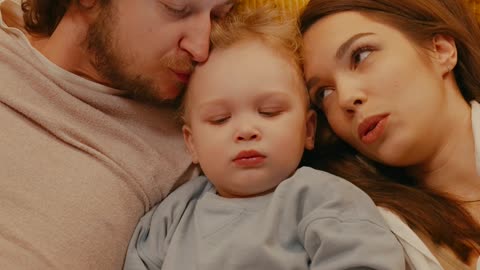 parents reading a book for their daughter