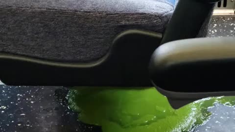 Green liquid on subway train under blue chair