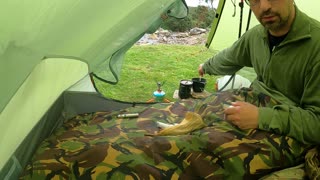 Making a brew in the tent by a stream