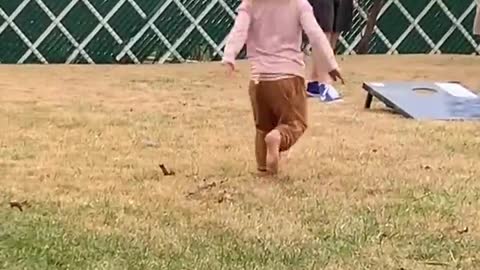 Little Girls Spins and Falls Down in Grass