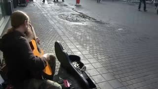 Street guitarist playing nylon guitar very fast