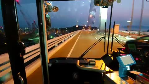 A Japanese bus runs on the road in the evening