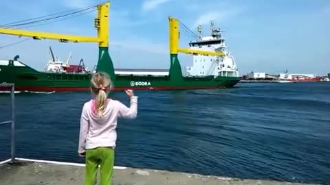 Girl honks at ship.