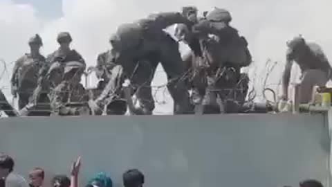 Toddler pulled over wall by U.S. soldiers as desperate crowds gather outside Kabul airport. 8.19.21.