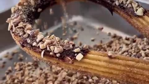 Handcrafted churro with chocolate and almonds