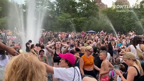 Children and adults are playing together at a clothing-optional #Pride event water party