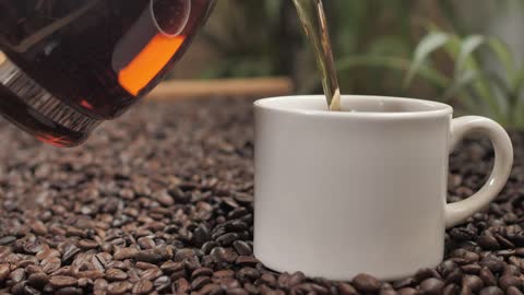 Serving coffee in a cup on coffee beans